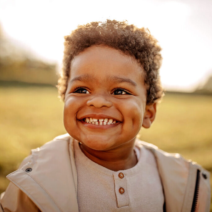 A happy young boy smiling brightly because his mom found a stress-free way to contact pediatric dentist teams online